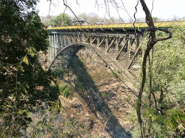 716-vicfalls-54.jpg - De Victoria Falls Bridge over de Zambezirivier, vlakbij de watervallen. De brug verbindt Zambia en Zimbabwe. Over de brug loopt een spoorlijn, een autoweg en een voetpad. De brug wordt gebruikt om te bungeespringen.